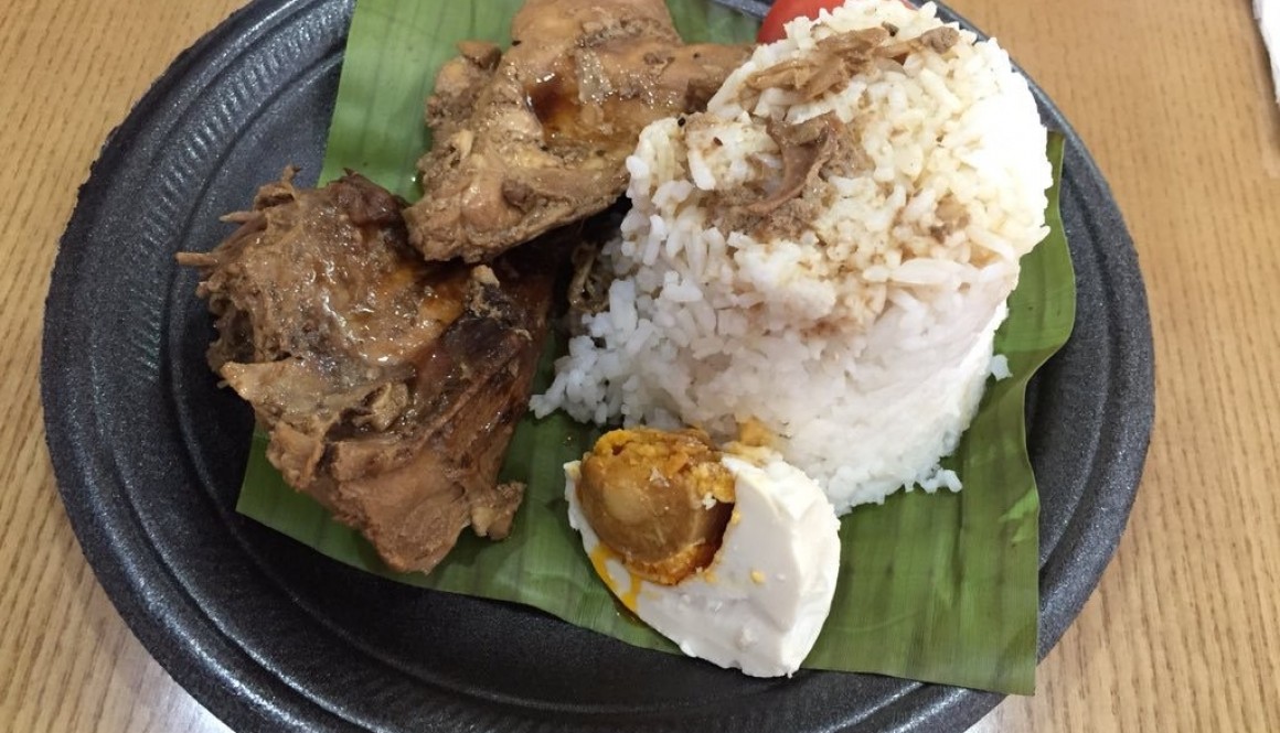 Chicken adobo with rice, and salted egg on banana leaf.